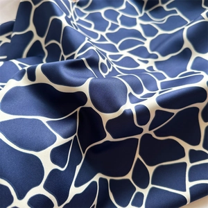Détail de la texture en sergé d'un foulard en soie à motifs géométriques bleu marine