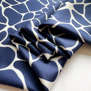 Vue détaillée d'un foulard en soie sergé à motif girafe bleu marine et blanc avec plis
