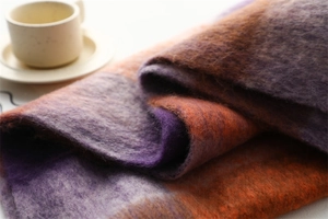 Gros plan détaillé de l'écharpe épaisse à carreaux violet et orange à franges douces