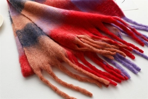 Gros plan d'une écharpe en maille multicolore épaisse montrant la texture et les franges