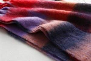 Gros plan d'une écharpe épaisse à carreaux avec texture mohair et détails de franges