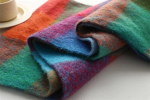 Gros plan d'une écharpe épaisse en dégradé avec texture mohair multicolore et franges douces