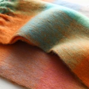 Vue macro d'une écharpe en cachemire doux montrant des dégradés de couleurs et franges