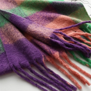 Gros plan d'une écharpe d'hiver épaisse avec carreaux violet orange et longs glands