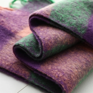 Vue détaillée de l'ourlet à franges et de la texture épaisse du foulard à carreaux