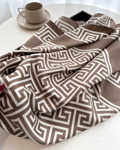 Détail d'un foulard en soie marron et beige avec motif géométrique de clé grecque