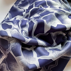 Détail d'un foulard en soie bleu marine et blanc montrant le tissage sergé et la texture