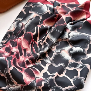 Détail du foulard en soie dégradé montrant la texture luxueuse et les bords roulés