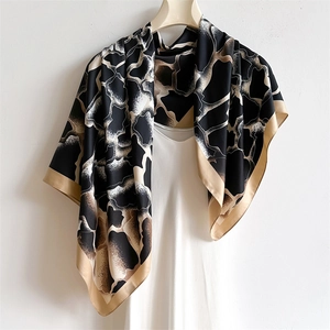 Détail d'un foulard en soie avec imprimé animal abstrait et texture lisse sur un cintre
