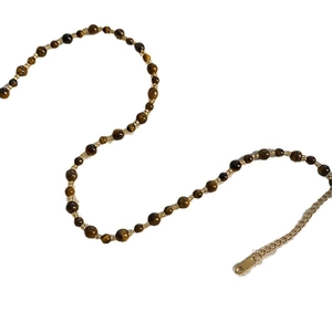 Vintage handmade beaded necklace with tiger eye stones and golden spacers on white backdrop