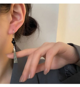 Macro shot of long New Chinese style earrings with black beads and grey pendants