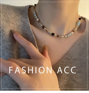 Detail of beaded necklace with blue and brown glass beads on a grey knit background