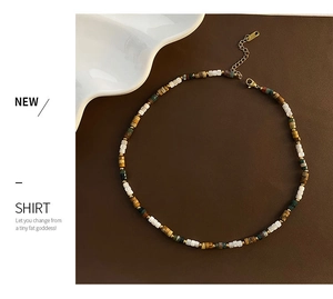 Détail du collier de perles en œil de tigre et pierre avec fermoir doré ajustable