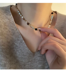 Detailed close-up of ethnic beaded necklace with colorful glass beads and pearls on neck