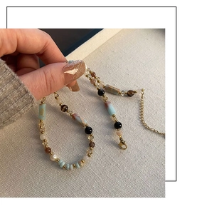 Close-up of ethnic beaded necklace featuring blue stone tubes and gold lobster clasp