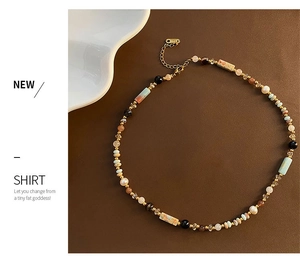 Detail of colorful beads, white pearls, and gold clasp on a retro ethnic style necklace