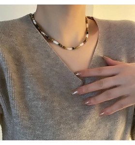 Détail du collier en pierres naturelles avec œil de tigre et perles vertes sur modèle