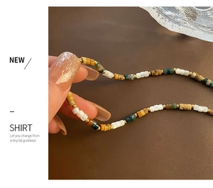 Détail d'un collier de perles en pierre naturelle avec des séparateurs dorés