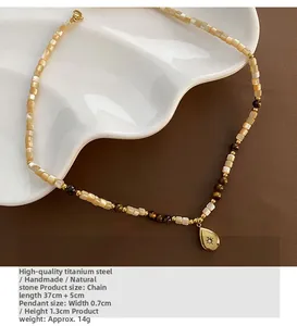 Detail of beaded tiger eye necklace with waterdrop pendant on a white ceramic plate