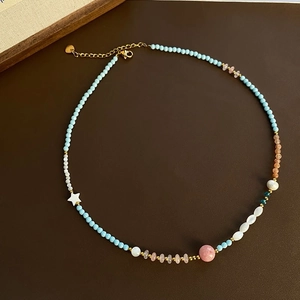 Macro shot of colorful beaded collar necklace with strawberry quartz and golden clasp