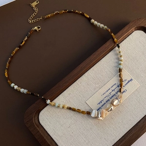 Macro view of tiger eye stones and iridescent mother of pearl on a beaded necklace