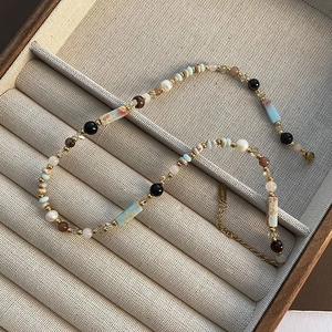 Detail of handcrafted clavicle necklace with strawberry quartz and natural gemstones
