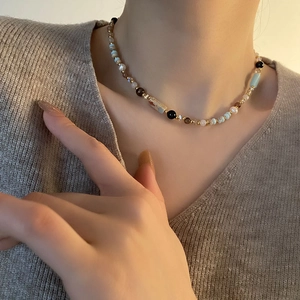 Ethnic beaded necklace with turquoise and pearls on model in warm studio lighting