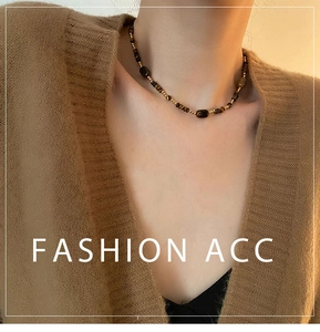 Détail d'un collier de perles vintage avec pierres oeil de tigre et billes dorées