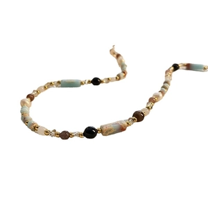 Ethnic bohemian style necklace with blue stones and mixed beads on white background