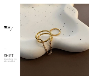 Polished gold double-layer chain ring set on white ceramic tray background