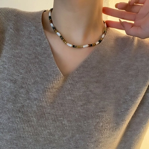 Collier rétro perles multicolores et perles dorées porté par un mannequin en col en V