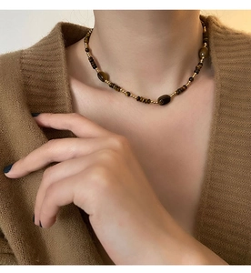 Gros plan d'un collier vintage en perles d'oeil de tigre avec des accents dorés