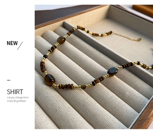 Gros plan du collier en perles d'oeil de tigre et perles d'eau douce dans un coffret