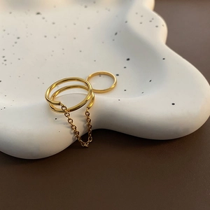 Minimalist double-layer chain connector ring set in bright gold finish on white ceramic