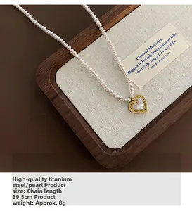 Detailed close-up of heart pendant necklace with white shell beads on a wooden tray