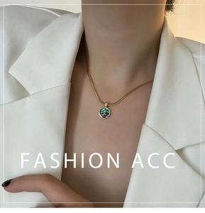 Detailed close-up of a golden rose relief on an iridescent abalone shell pendant necklace
