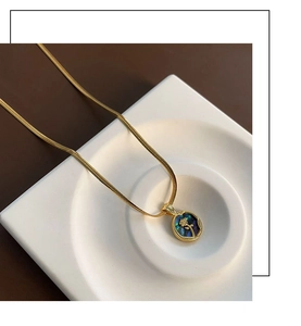 Close-up of golden necklace featuring a vintage flower pendant with iridescent shell inlay