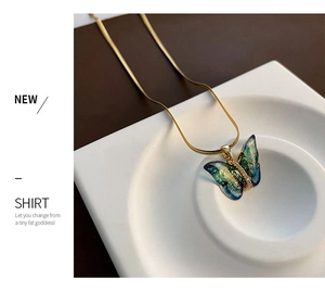 Vue détaillée d'un pendentif papillon avec zircons sur une chaîne serpent dorée