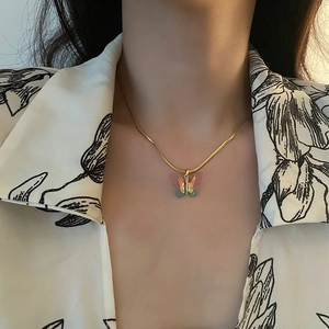 Collier avec pendentif papillon doré et détails en zircon sur une fine chaîne serpent