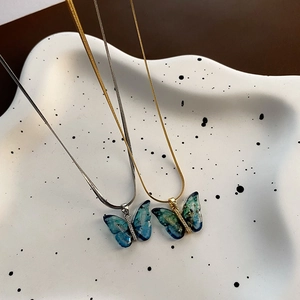 Collier avec pendentif papillon exquis en résine turquoise, feuille d'or et zircons