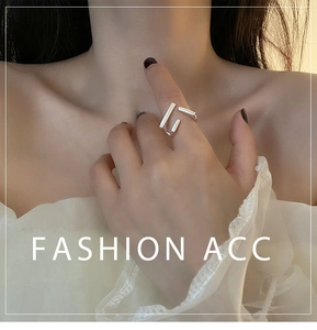 Close-up of a silver geometric ring with irregular rectangular blocks on a model's hand