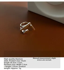 Detail shot of a minimalist geometric titanium steel ring on dark textured leather background