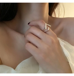 Close-up of geometric silver open ring featuring a triple layered architectural design