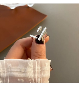Close-up of geometric silver ring with minimalist irregular square lines on a finger