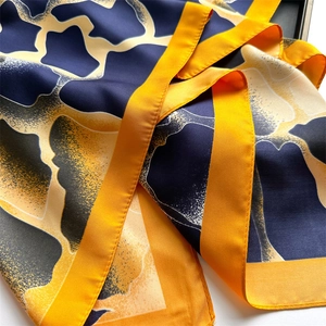 Détail d'un foulard en soie avec imprimé animal bleu et jaune et texture satinée