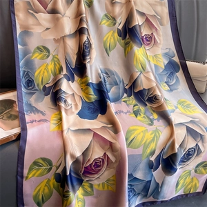Detailed view of large floral print silk scarf with purple roses and satin finish