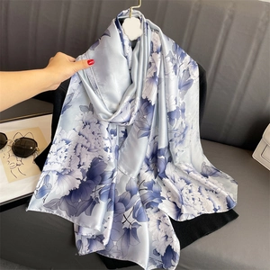 Detail of silk satin shawl showing dark blue peony floral print on light blue fabric