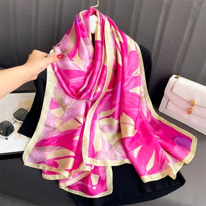 Detail of floral print silk shawl with vibrant peach and magenta blossoms texture