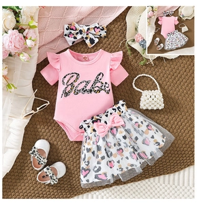 Flat lay of baby girl Babe bodysuit with leopard skirt set, headband, shoes and purse