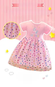 Detail of pink summer girl dress showing unicorn print and colorful heart sequins on tulle
